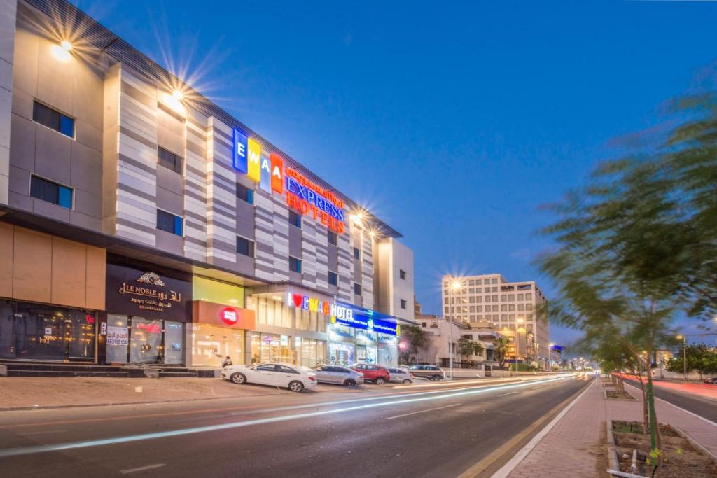 una calle de la ciudad con coches aparcados frente a un edificio en Ewaa Express Hotel - Al Rawda, en Yeda