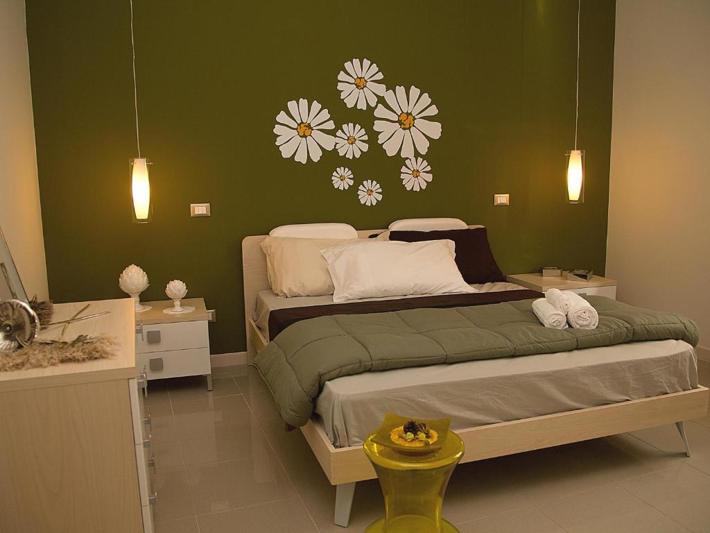 1 dormitorio con 1 cama con flores en la pared en La Conchiglia Case Vacanze, en Balestrate