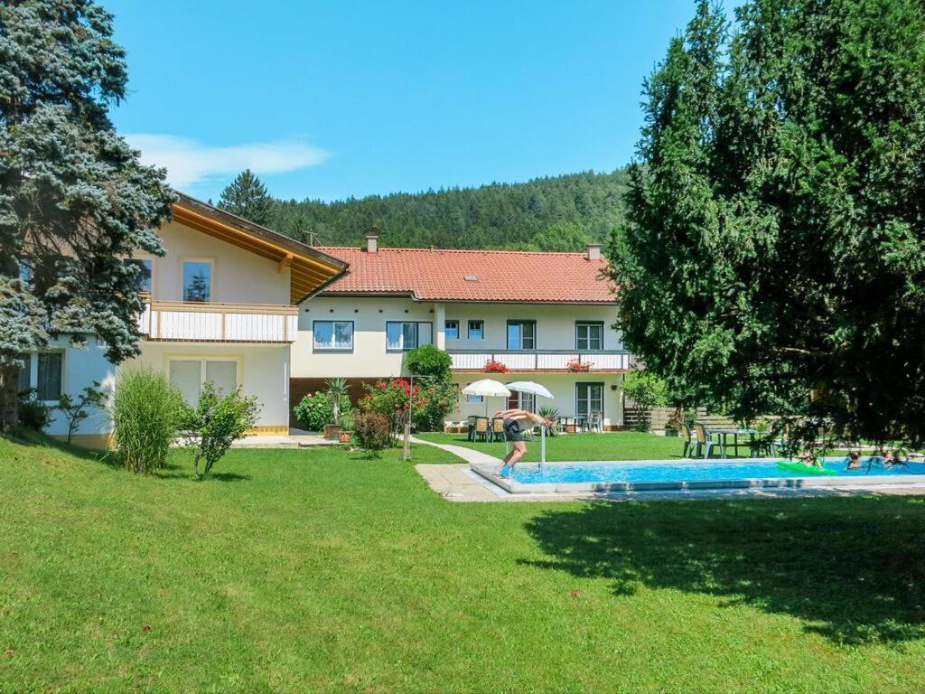 una casa grande con un patio con piscina en Apartments Roemerschlucht en Velden am Wörthersee
