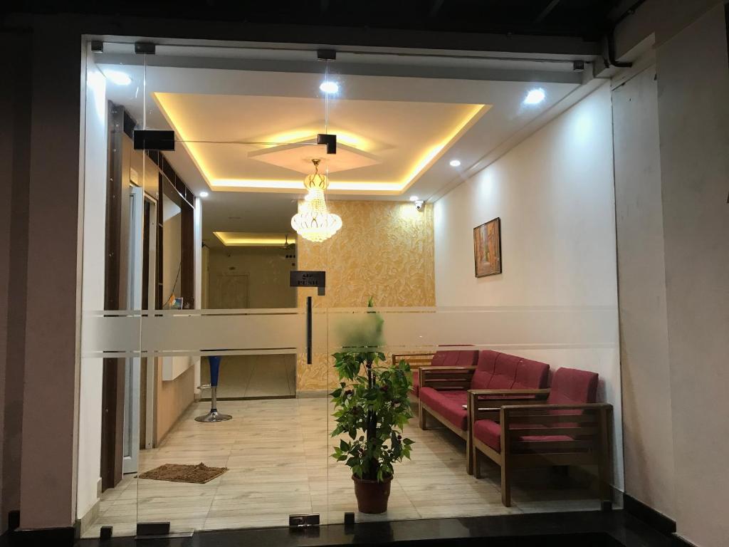 ein Wartezimmer mit Couch und Topfpflanze in der Unterkunft Sapphire Hotel Apartments & Business Suites in Kakkanad