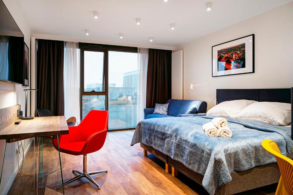 a bedroom with a bed and a desk and a red chair at EASY RENT- Aperta ART Centrum, Basen & SPA, Free Parking 24h Check-in in Lublin