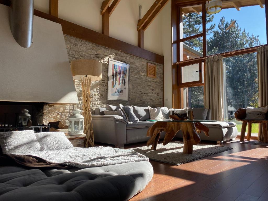 a living room with a couch and a large window at Pirin Golf and Spa Luxury Chalet in Bansko