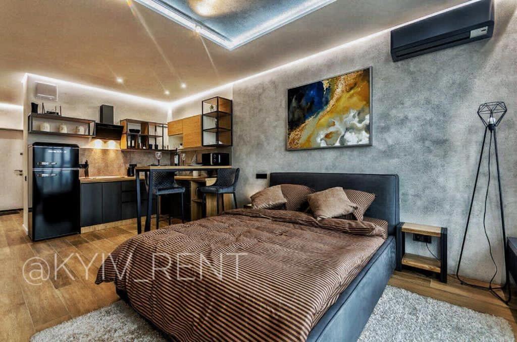 a bedroom with a bed and a kitchen at Modern VIP Smart. in Kyiv