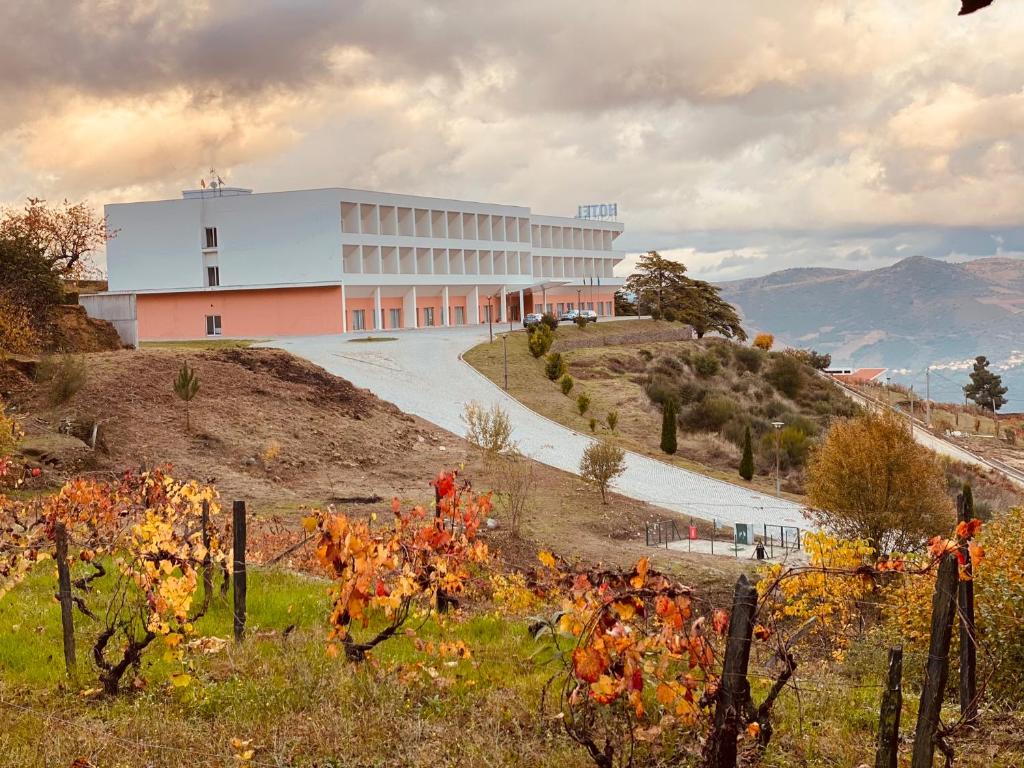 a white building on top of a hill at Placido Hotel Douro - Tabuaco in Tabuaço