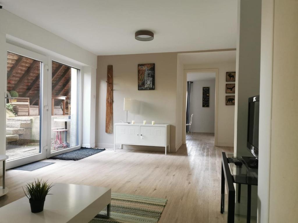 uma sala de estar com uma mesa e uma televisão em " Petit Cocon 67 " cosy F2 de 65m2 proche Strasbourg em Ittlenheim