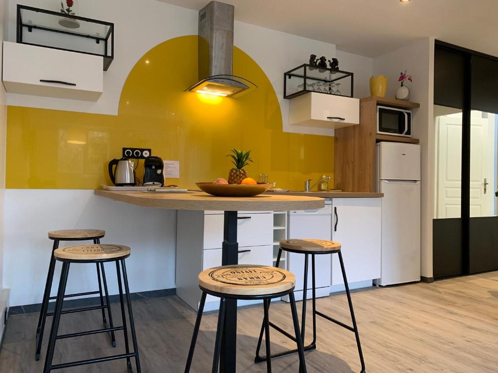 a kitchen with a counter and stools in a room at Foch in Le Havre