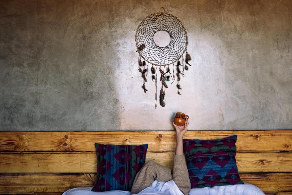 een persoon zit op een bank met een kroonluchter bij UvaUva eco-retreat in Valle de Guadalupe