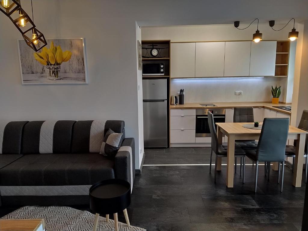 a living room and kitchen with a couch and a table at Apartament 36 in Nowy Targ