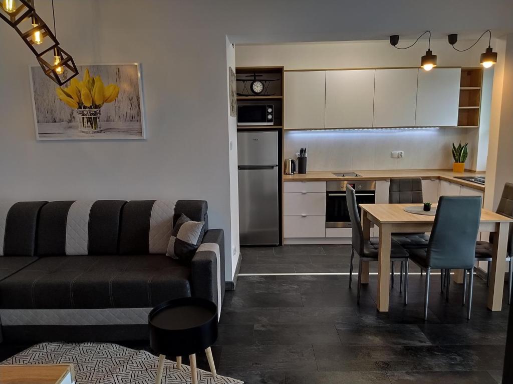 Una sala de estar y una cocina con un sofá y una mesa. en Apartament 36, en Nowy Targ