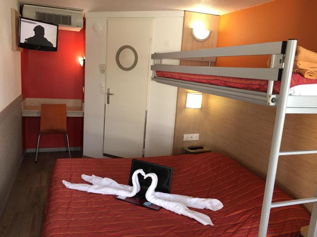 a bedroom with a bunk bed with two white towels at Premiere Classe Dunkerque Saint Pol Sur Mer in Saint-Pol-sur-Mer