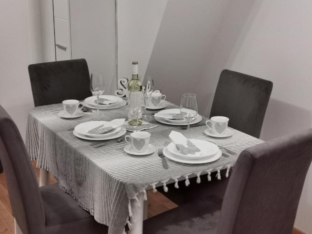 een eettafel met een wit tafelkleed en stoelen bij Apartman Divcigora Sokic in Divčibare