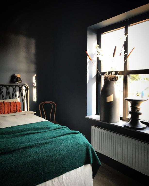 a bedroom with a green bed and a window at Sångbergs Hotell in Tranemo