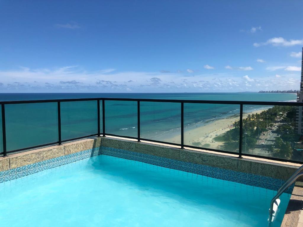 a swimming pool with a view of the ocean at Lindo Apartamento - Beira Mar de Boa Viagem in Recife
