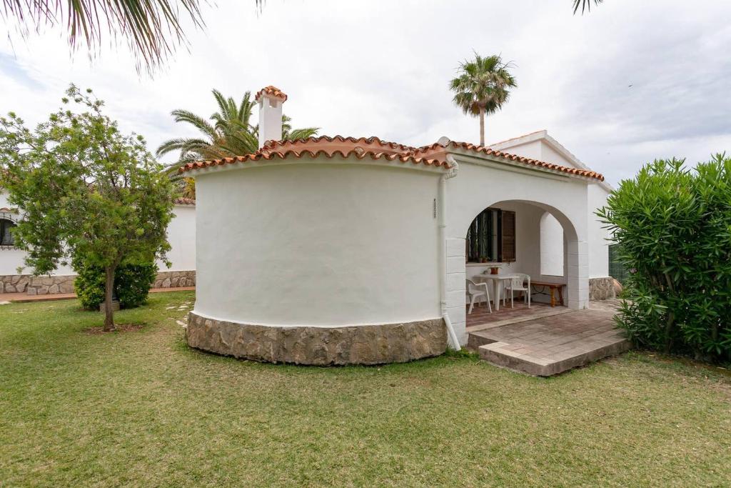 ein kleines weißes Haus mit einem Tisch im Hof in der Unterkunft Villa Marina in Denia