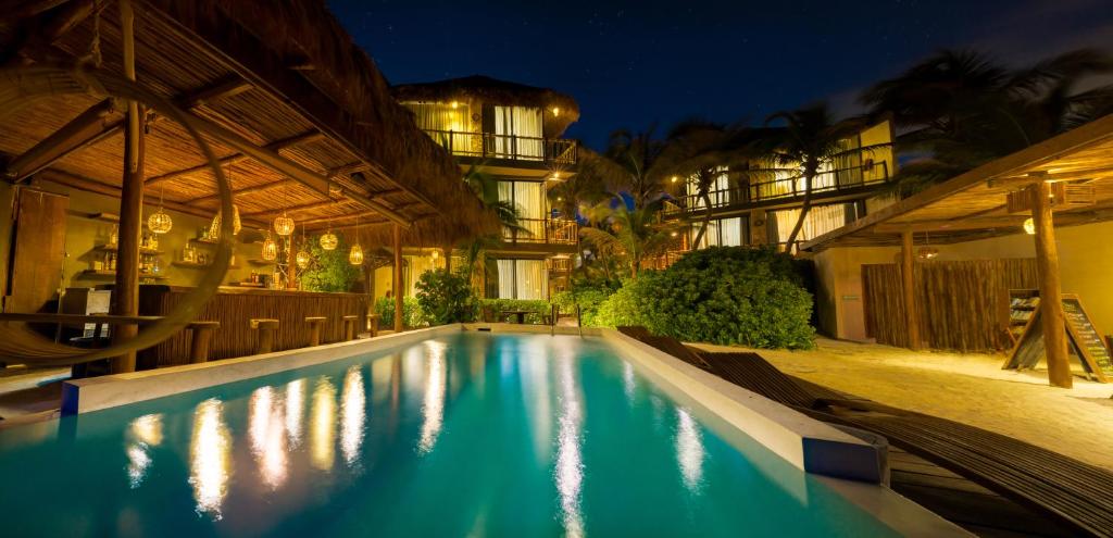 a swimming pool in front of a building at night at Akkuun Tulum - Adults Only in Tulum