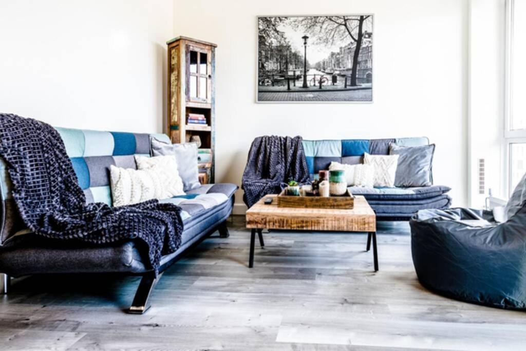 a living room with a blue couch and chairs at Casa Plantin with parking place at the beautiful city park! in Antwerp