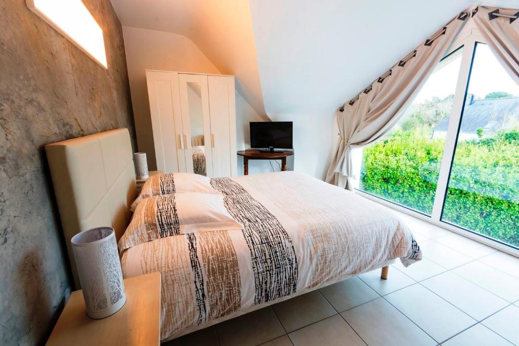 - une chambre avec un lit et une grande fenêtre dans l'établissement Lomener - La Goelette - 1 appartement avec 2 chambres et 2 studios à 450m de la plage, à Ploemeur