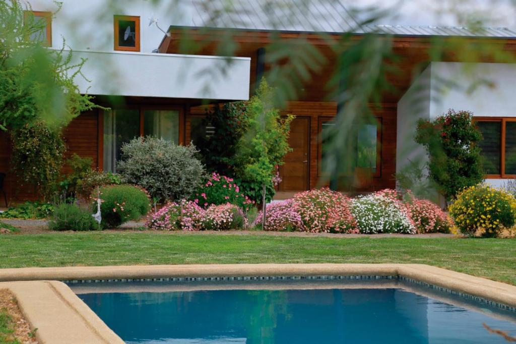 a house with a swimming pool in front of a house at Callihue Lodge in Santa Cruz