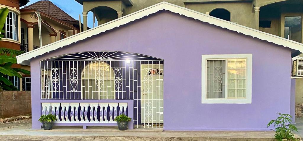 une maison violette avec un portail dans l'établissement The Intimate Paradise Close to 876 Beach, à Falmouth