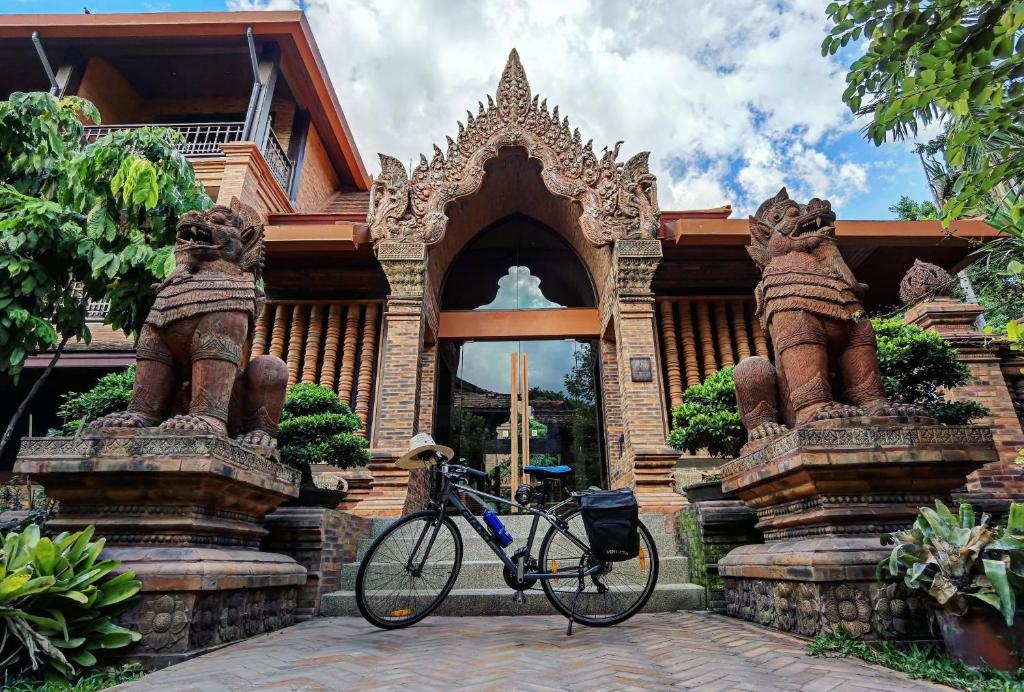 a bike parked in front of a stone building at Phor Liang Meun Terracotta Arts - SHA Extra Plus in Chiang Mai