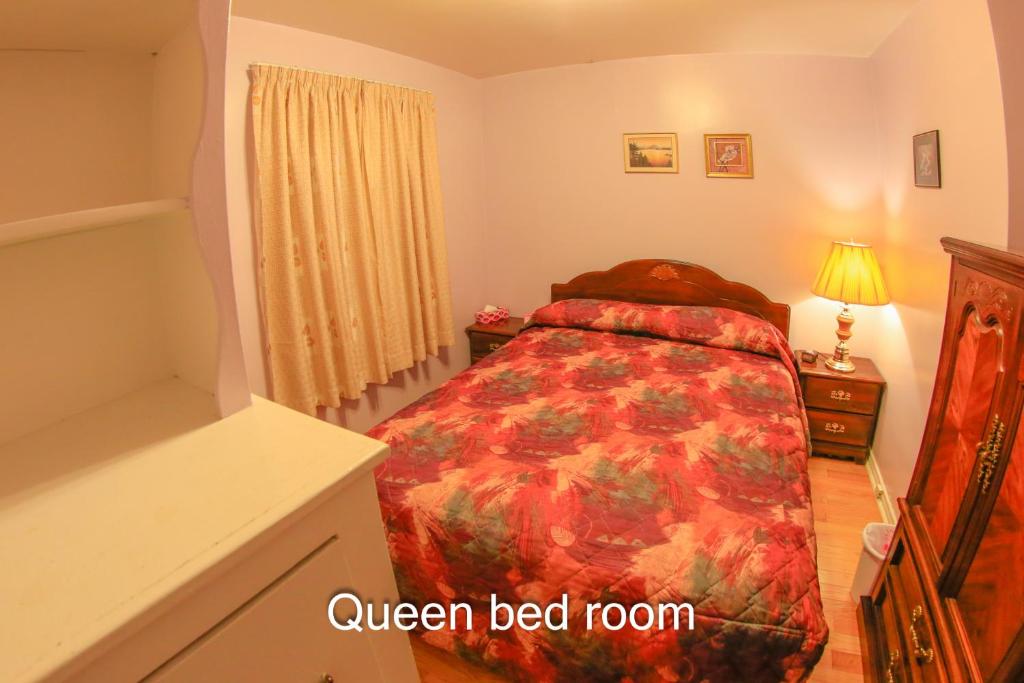een slaapkamer met een bed met een rood dekbed bij Comfort Home Toronto in Toronto