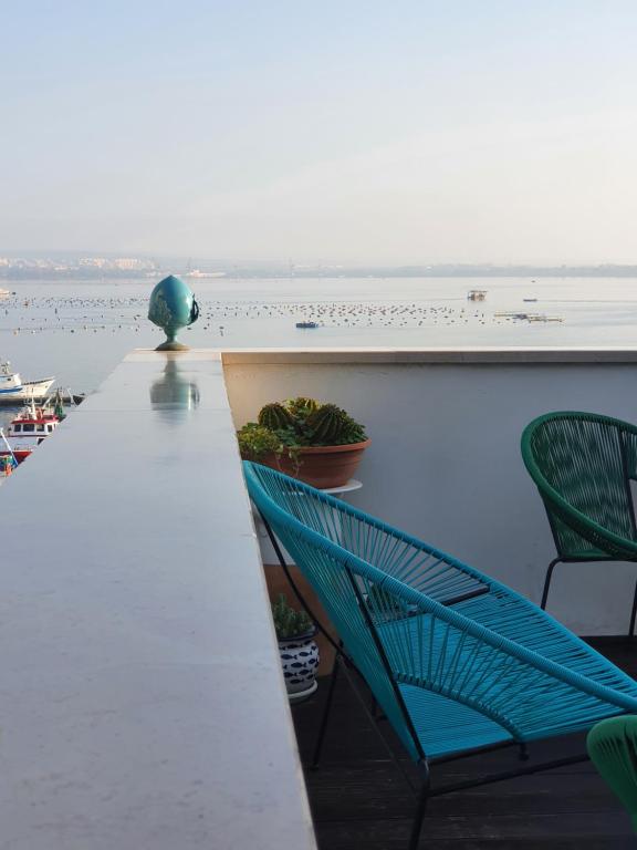 einen Tisch und Stühle auf einem Balkon mit Blick auf das Wasser in der Unterkunft B&B La Terrazza di NonnAnna in Taranto