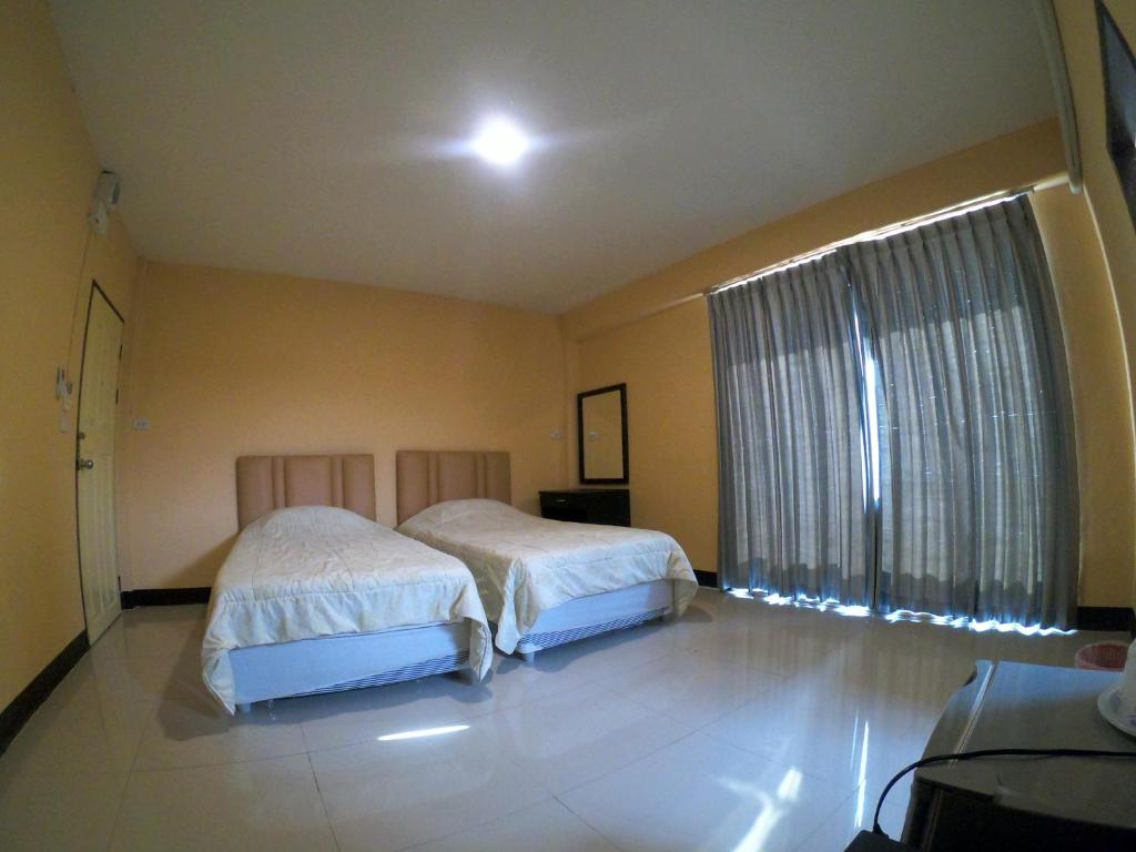 - une chambre avec 2 lits et une grande fenêtre dans l'établissement The One, à Phayao