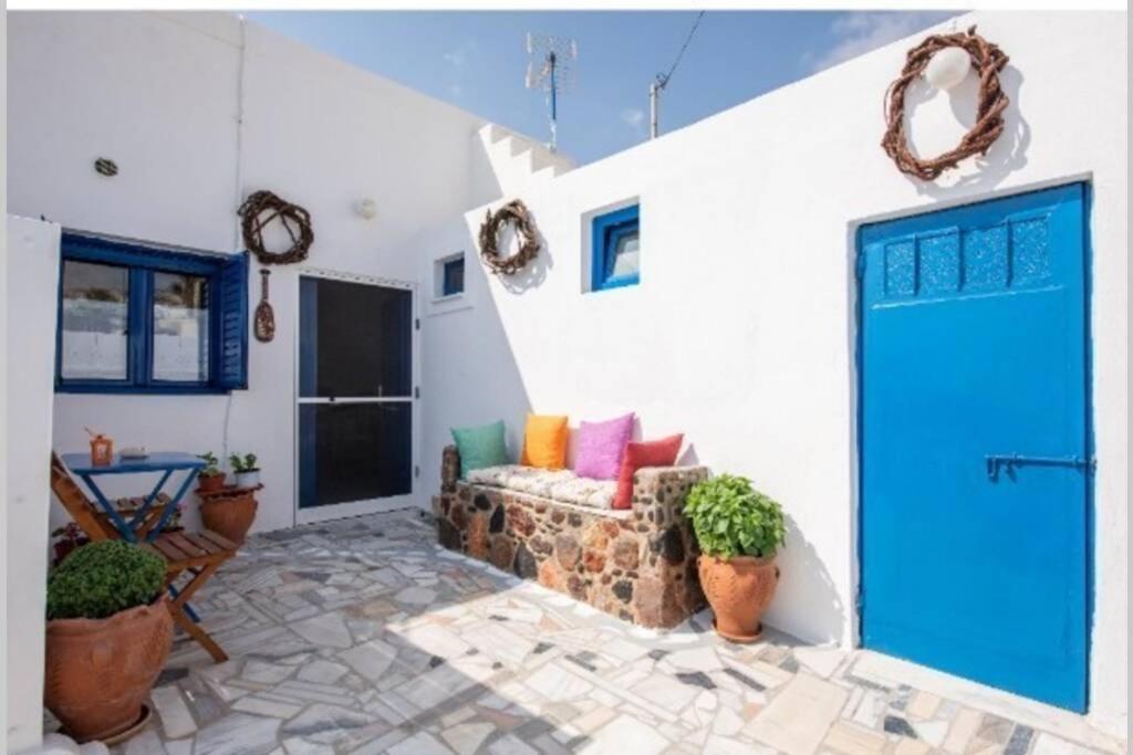 a living room with a blue door and a couch at easy going santorini house in Éxo Goniá