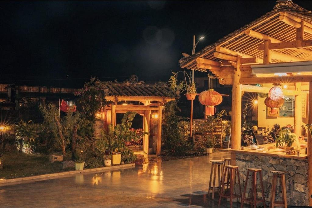 a patio of a restaurant at night with a bar at Meo Vac Clay House in Mèo Vạc