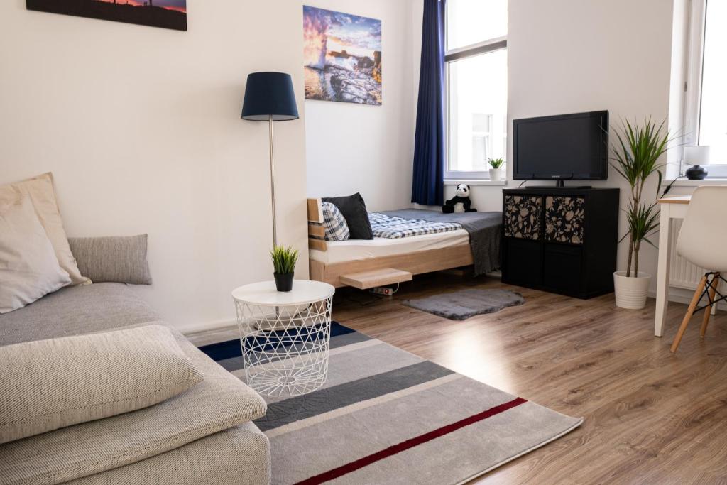 un soggiorno con divano e TV di FULL HOUSE Studios - Blue Apartment - WiFi inkl a Magdeburgo