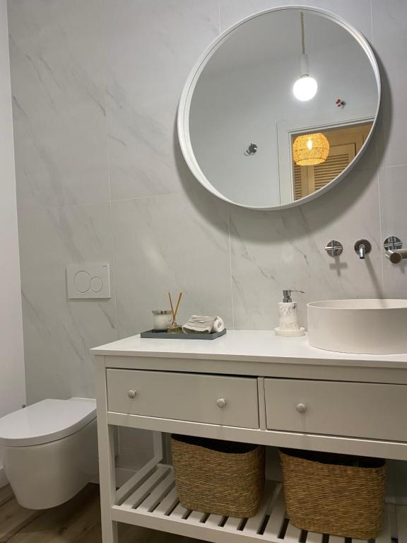 Un baño blanco con lavabo y espejo. en BBA Moledo - Beachfront Apartment, en Moledo