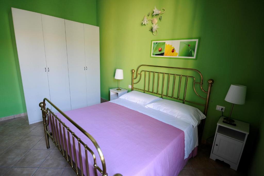 Dormitorio verde con cama con manta rosa en B&B Calcio Storico, en Florencia