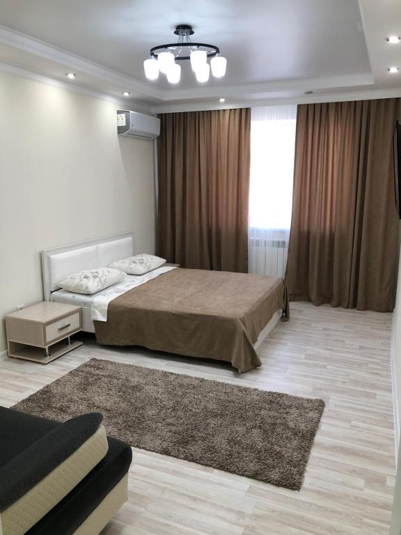 a large bedroom with a bed and a couch at Apartment Батыс 2, 44 in Aktobe