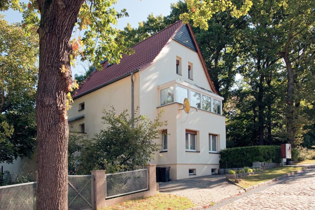 una casa blanca con techo negro en Pension Rosengarten, en Sangerhausen