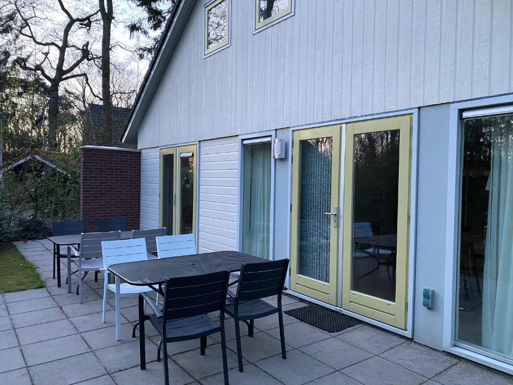 a patio with a table and chairs next to a house at Fonteinbos in Oudemirdum