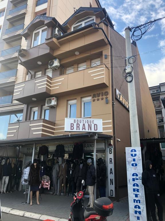 una tienda frente a un edificio con gente de pie fuera en Avio Apartmani 2018 en Novi Pazar