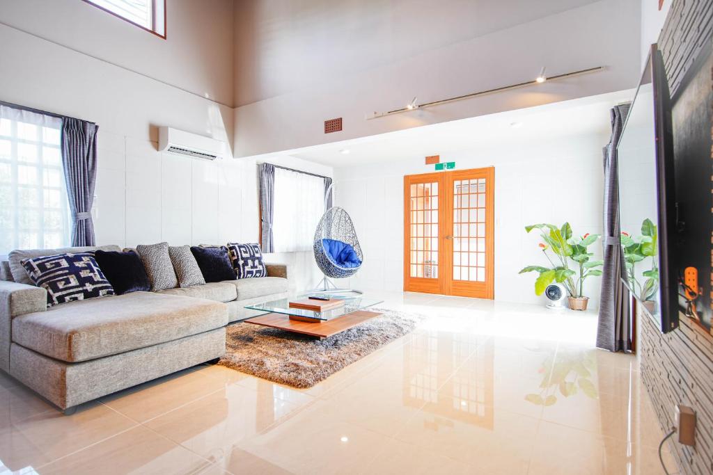 uma sala de estar com um sofá e uma mesa em ITOMAN SEA pension 大度 MIM em Ōdo