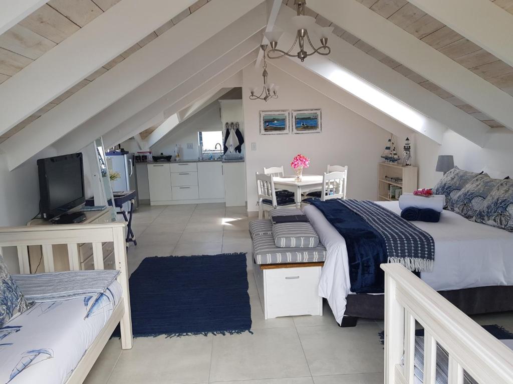 a bedroom with two beds and a living room at The Loft on Malmok in Paternoster