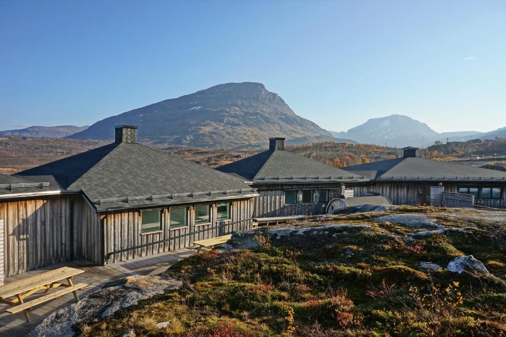 a large building with mountains in the background at Arctic Lodge in Riksgränsen
