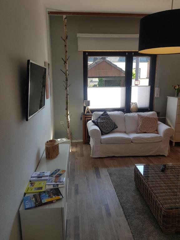 a living room with a white couch and a table at Ferienhaus Wallstraße in Rees