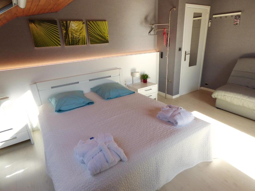 Un dormitorio con una cama blanca con toallas. en B&B Le Jardin d'Epicure, en Olne