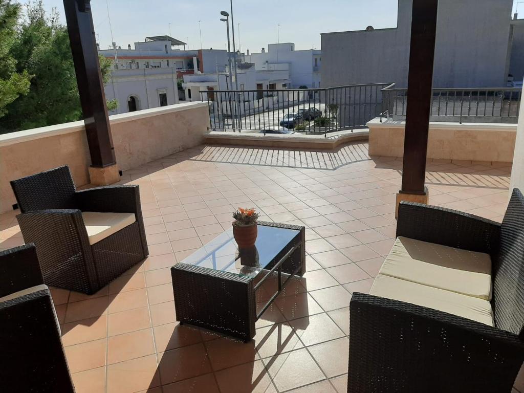 a patio with chairs and a glass table on a balcony at LaRosa Maruggio in Maruggio