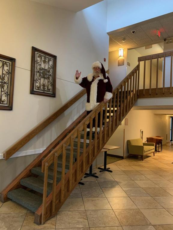 un hombre vestido como Santa Claus de pie en las escaleras en Nichols Inn & Suites en Hastings