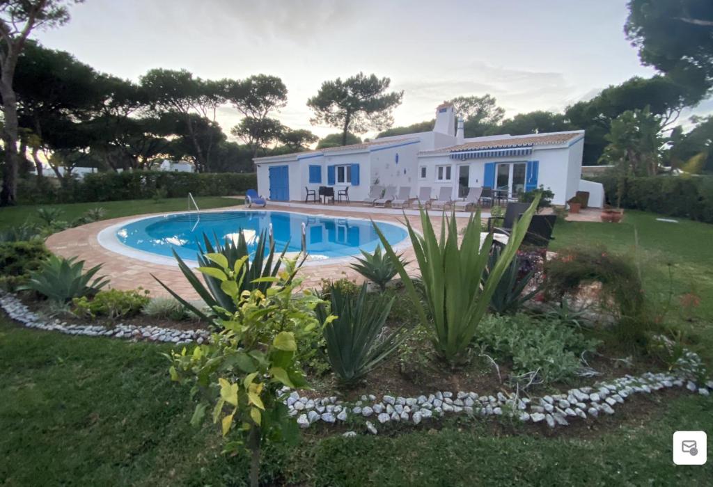 een huis met een zwembad in de tuin bij Villa CHELSEA in Vilamoura