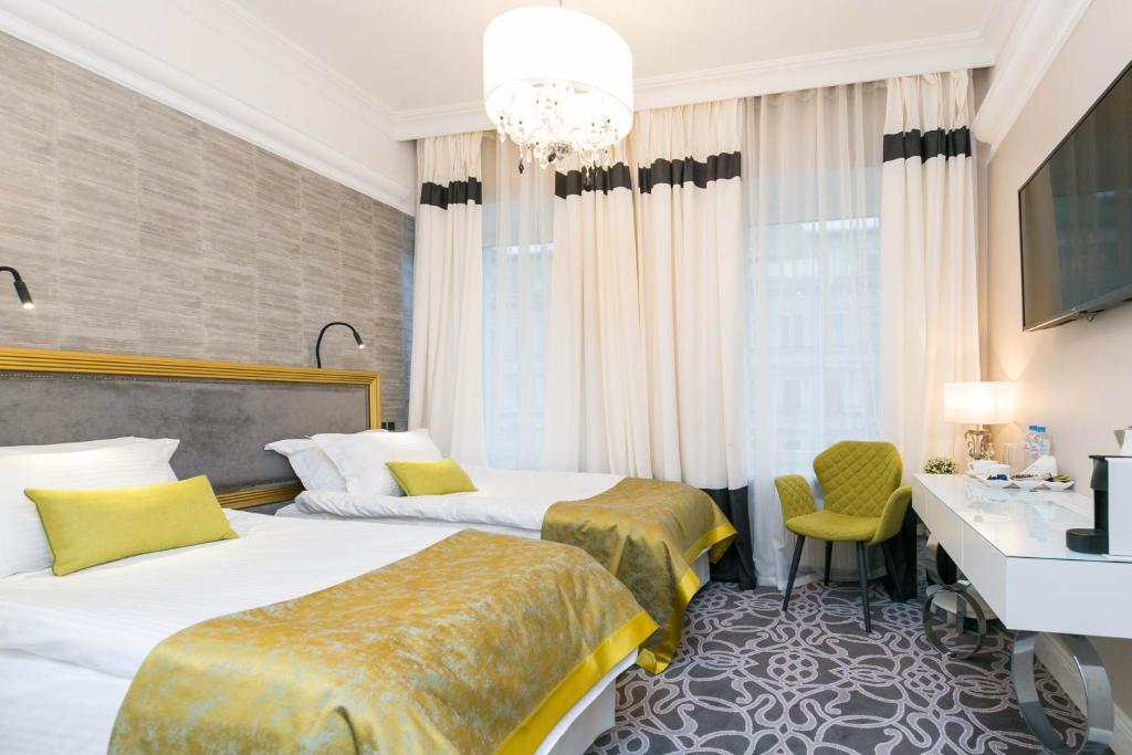 a hotel room with two beds and a desk at Orfei GOLD in Saint Petersburg