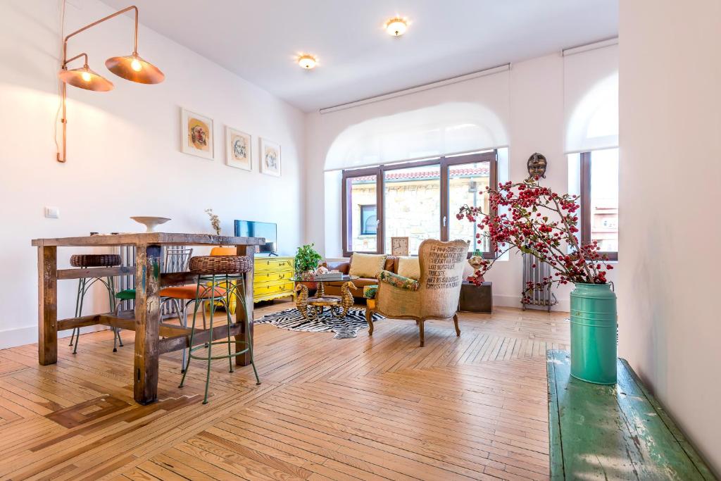 uma sala de estar com mesa e cadeiras em Singular loft en los pinares de Covaleda, Soria em Covaleda