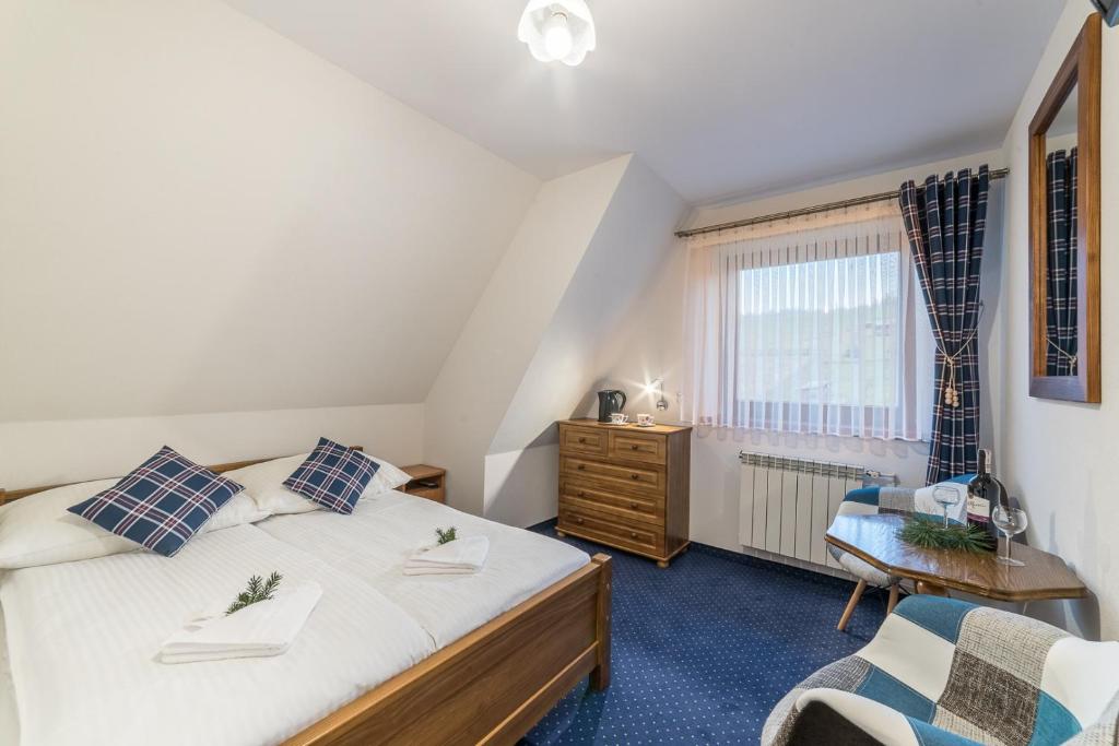 een slaapkamer met een bed, een stoel en een raam bij Pokoje Gościnne u Bronka in Ciche Małe