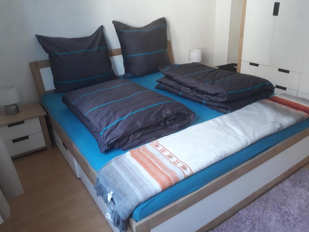 - un lit avec 2 couvertures et des oreillers dans l'établissement Ferienwohnung MacFeWo im Zentrum von Mayen, à Mayen