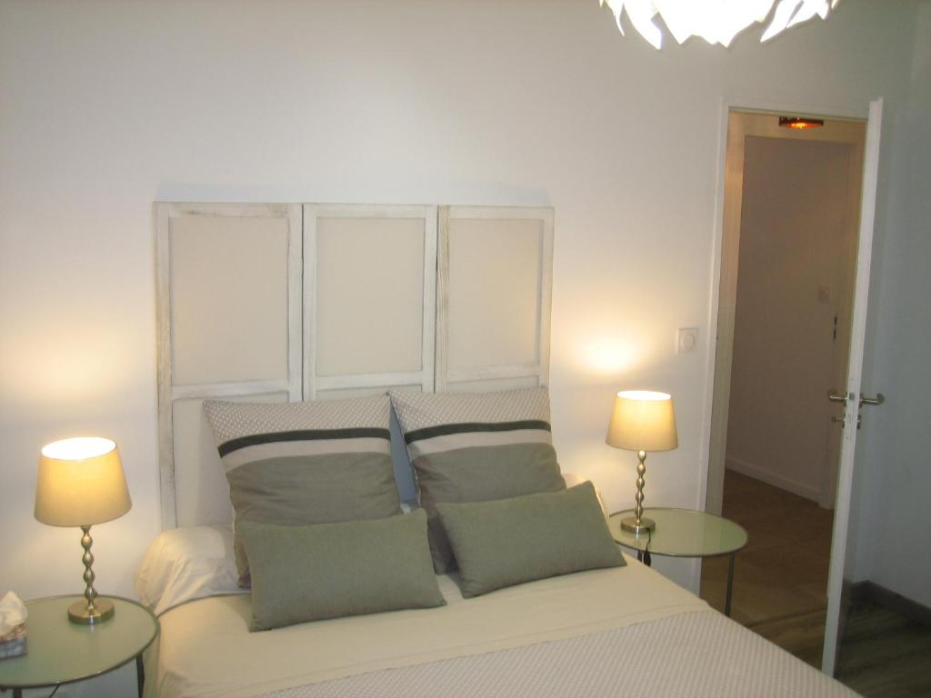 1 dormitorio con 1 cama blanca y 2 lámparas en AGATHE chambres d'hôtes, en Guérande