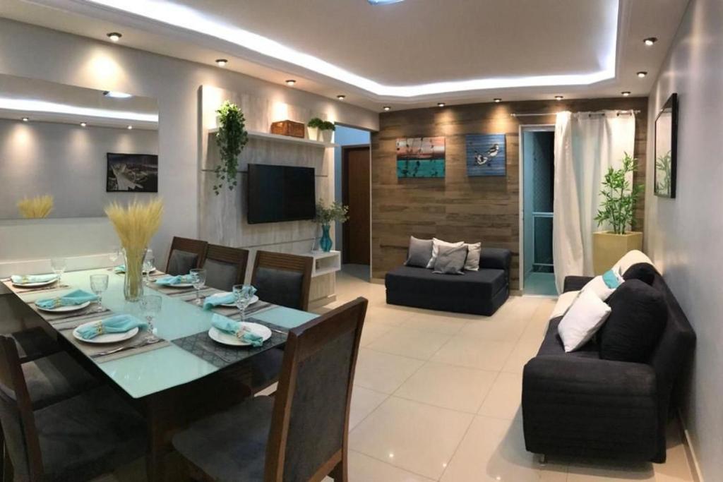 comedor y sala de estar con mesa y sillas en Apartamento espetacular com clube privativo, en Cabo Frío